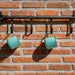 350ML Camping Stainless Steel Insulated Mug - A drink bottle with an insulated design, featuring a light turquoise colour and a hanging loop, displayed on a brick wall.