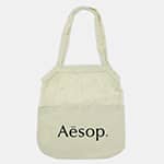 Maglia Cotton Shopping Tote - A light cream cotton shopping tote with a logo on the front and two handles.