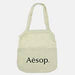 Maglia Cotton Shopping Tote - A light cream cotton shopping tote with a logo on the front and two handles.