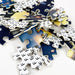 Custom Gift Box Jigsaw Puzzle - A pile of jigsaw puzzle pieces featuring a cosmic design in blue, yellow, and black hues, with some pieces showing a grid pattern.