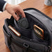 Everest 3-in-1 15W Magnetic Wireless Charging Station - A black magnetic wireless charging station is placed inside a dark bag alongside a phone and a notebook.