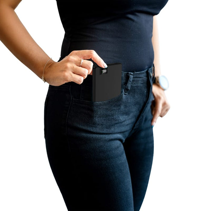 Bryan Ultra Thin 15W MagSafe Power Bank - 5000 mAh (Stock) - A black 15W MagSafe power bank being pulled from a pocket, featuring a slim design. It has a logo on the surface.
