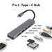 Hayden Type-C Hub (Type-C, Type-A, HDMI, PD100W) - A grey 7-in-1 Type-C hub featuring various ports including HDMI, USB Type-C, USB 2.0/3.0, and a card reader.