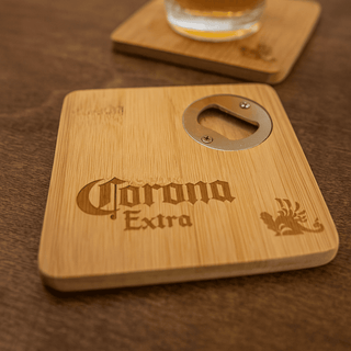 Square Bamboo Coaster - A square bamboo coaster featuring a bottle opener and a logo, set on a wooden surface with a drink.