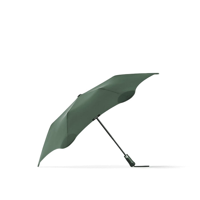 BLUNT Metro Umbrella - A green BLUNT Metro umbrella with a sleek design and a sturdy black handle, featuring a logo.