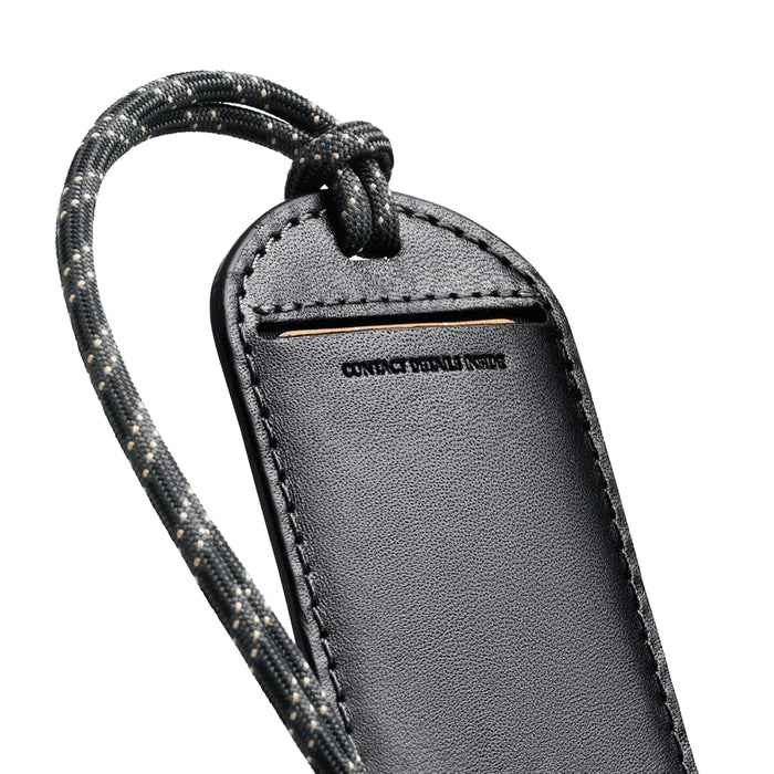 Bellroy Luggage Tag - A black luggage tag with a textured surface and a patterned strap, featuring a branding logo.
