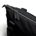 Bellroy Classic Tote - A black tote bag features a zip closure with leather zip pulls and a sturdy handle. It has a sleek, minimal design.