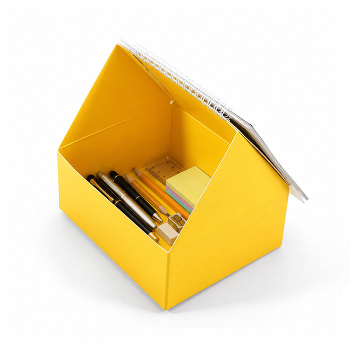 Desk Calendar With Organizer - A yellow desk calendar and organiser shaped like a house, filled with pens, sticky notes, and stationery supplies.