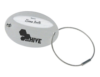 Triton Luggage Tags, oval - Oval luggage tag in silver with a wire loop and a section for personal details, featuring a logo.