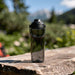 CamelBak - Thrive Chug 0.6L - A drink bottle in a sleek, transparent design with a black lid and handle, set against a natural outdoor backdrop.