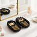 9 Brushes in a Case - A black case containing nine makeup brushes with gold details, placed on a vanity beside a mirror and various beauty products.