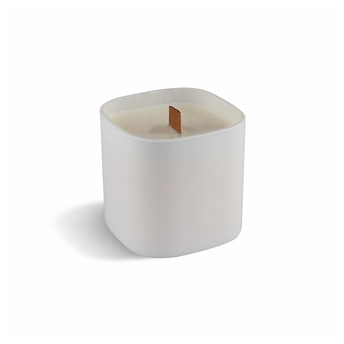 Premium Square Glass Candle - A premium square glass candle in white, featuring a wood wick. It has a smooth, minimalist design and a logo.