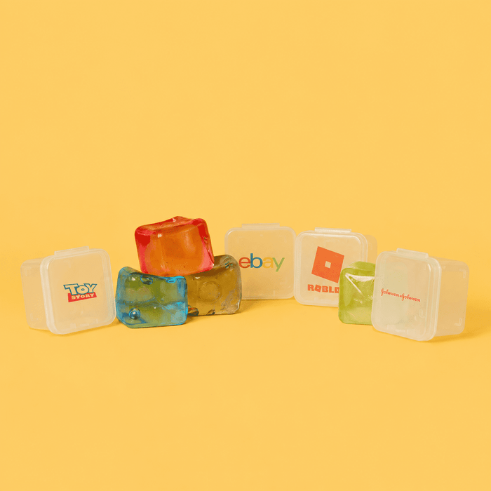 Jelly Cube Sensory Toy - Jelly Cube sensory toys in various colours, featuring a promotional logo on one cube against a bright yellow background.