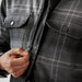 Men's Highland Sherpa Lined Plaid Jacket - A men's plaid jacket in shades of grey, featuring a Sherpa lining and front pockets, with a zipper being fastened.