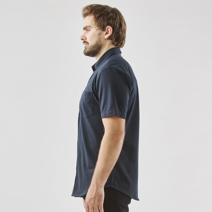 Men's Sonora Short Sleeve Knit Shirt - A dark navy short sleeve button-up shirt displayed on a model from the side, featuring a pocket and a logo.
