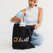 Colourful Calico Tote Bag - A black tote bag with a logo, being held by a person, while they reach inside for a drink bottle.