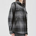Women's Highland Plaid Shacket - A women's Highland plaid shacket in black and grey, featuring a button-up front and two chest pockets.