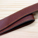 Saint-Rémy Cooler Basket - A brown faux leather strap with contrasting yellow stitching, laid flat on a wooden surface.