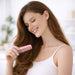Custom Blended-Tooth Comb - A woman with long hair holds a pink comb, smiling gently in a bright, softly lit setting.