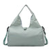 Duffle Bag With Yoga Mat Strap - A light green duffle bag with a yoga mat strap, featuring a logo and adjustable shoulder strap.