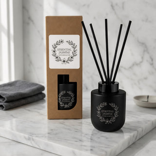 Botanical Reed Diffuser – 150ml - A black botanical reed diffuser with essential jasmine fragrance, accompanied by a brown box and black sticks, on a marble surface.