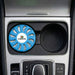 Air Freshener – Ocean - A blue air freshener with a circular design, placed in a car's cup holder. It has a logo on it.