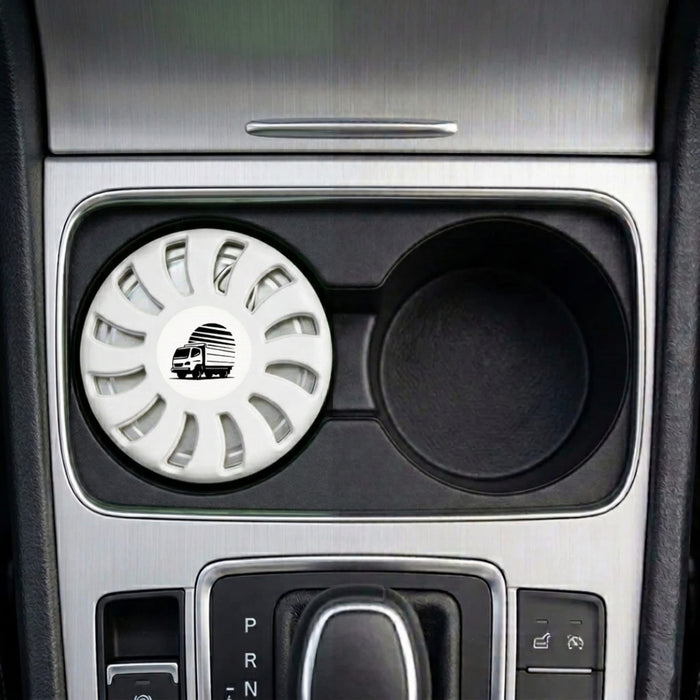 Air Freshener – Jasmine - A white air freshener sits in a car cup holder, featuring a circular design and a logo.