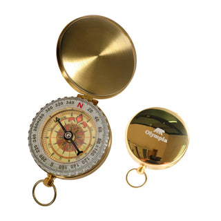 Luminous Compass - A golden compass with a decorative dial and a logo on the lid, featuring a keychain attachment.