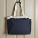 Field & Co.® Parks 16" Computer Work Tote - A navy blue tote bag with cream handles, featuring a logo on the front, hanging against a wall.