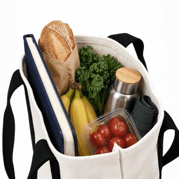Mini Canvas Tote - A mini canvas tote in cream filled with a loaf of bread, vegetables, a drink bottle, bananas, and a notebook.