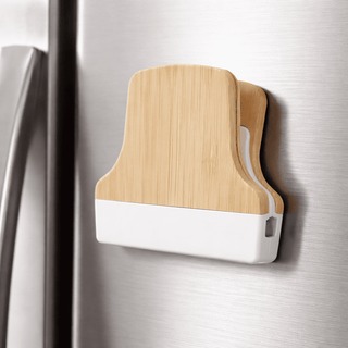 Bamboo Fridge Magnet Clip - A bamboo fridge magnet clip with a wooden back and white plastic base, attached to a stainless steel fridge.
