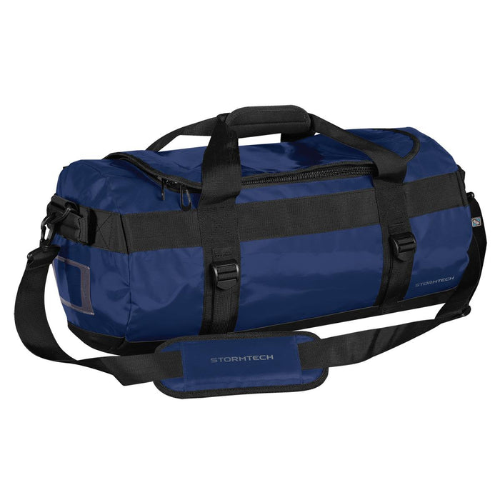 Stormtech Gear Bag Small - A small blue duffle bag with black straps and branding, featuring a zippered top and side grab handle.