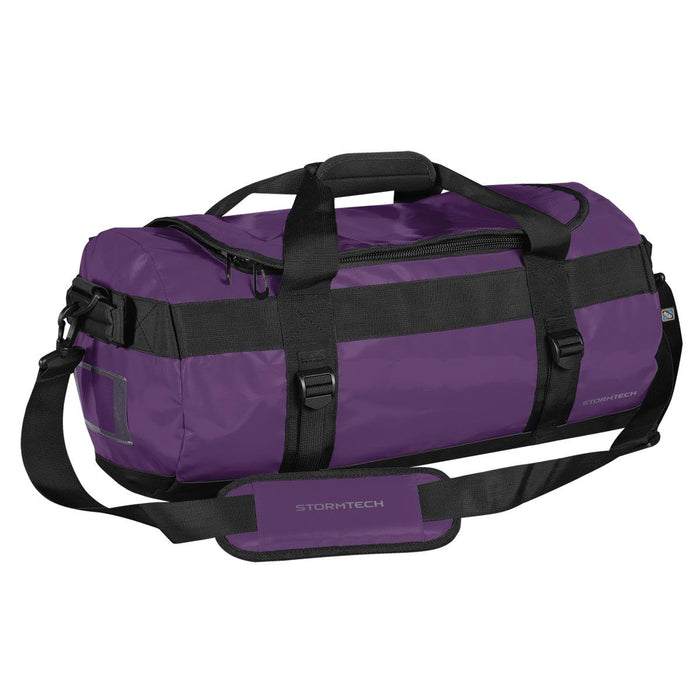 Stormtech Gear Bag Small - A small duffle bag in purple with black straps, featuring a handle, adjustable shoulder strap, and a logo.