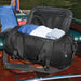 Stormtech Gear Bag Small - A black duffle bag with clothes inside, featuring a zippered top and a logo on the side.