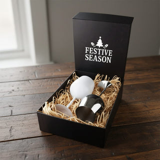 Bella Stainless Steel Wine Glas - A gift box containing a white egg and a stainless steel wine glass, resting on straw. The box has a festive design.