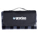 Outdoor Pack - A picnic blanket in grey and black, folded with a carrying handle and a logo on the front.