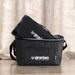 Outdoor Pack - A grey insulated bag with a black picnic blanket folded inside, featuring a logo on the bag.
