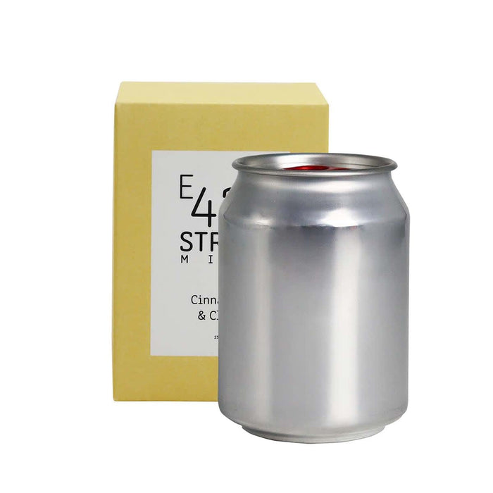 Mini East 42nd Street Can Candle - A silver can candle packaged in a yellow box, featuring a simple logo on the can.