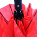 Poppins Umbrella - A red umbrella with a black handle and a logo, featuring multiple panels.