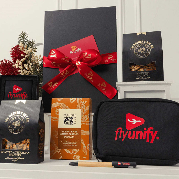 Branded Tech Kit Gift Pack - A gift box with a red ribbon, containing snacks, a black pouch, and a pen, all featuring a logo.