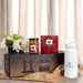Festive Essentials Set - A white drink bottle, a jar of jam, a box of tea, and a floral arrangement in a gift box.