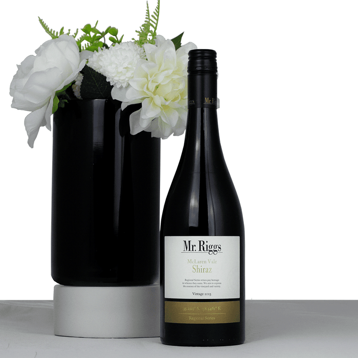 The Entertainer Set - A black wine bottle of Mr. Riggs McLaren Vale Shiraz, accompanied by a black vase with white flowers.