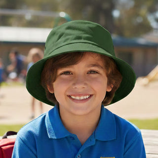 Long Beach Bucket Hat – Small - A green bucket hat on a smiling child, with a playground scene in the background. The hat has a logo.