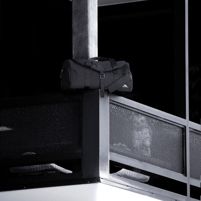 High Sierra Camille Duffel 31L - A black duffel bag rests on a balcony railing, featuring a logo and sturdy handles.