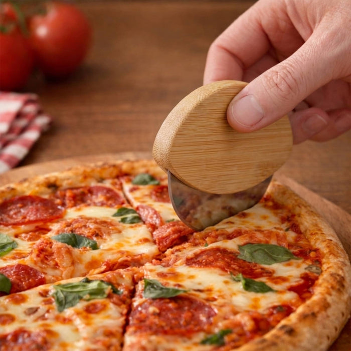 Bamboo Pizza Cutter - A bamboo pizza cutter with a rounded handle cuts through a pepperoni pizza on a wooden surface.