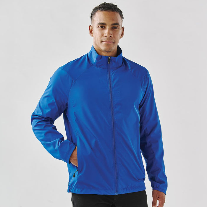 Men's Pacifica Full Zip Jacket - A blue full zip jacket with a collar, featuring a sleek design and side pockets, worn by a man.