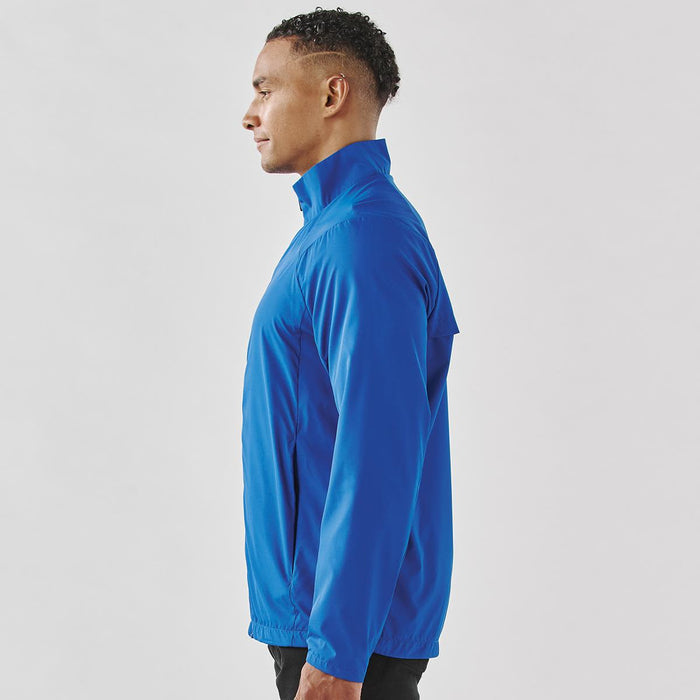 Men's Pacifica Full Zip Jacket - A men's full zip rain jacket in blue, featuring a high collar and a sleek design, worn by a model from the side.