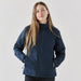 Women's Pacifica Thermal Jacket - A woman wearing a navy blue thermal jacket with a zippered front and side pockets, featuring a logo.