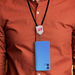 The Power Band Charging Lanyard - 60W - A blue phone is hanging from a black lanyard worn around a person's neck, featuring a logo at the top.