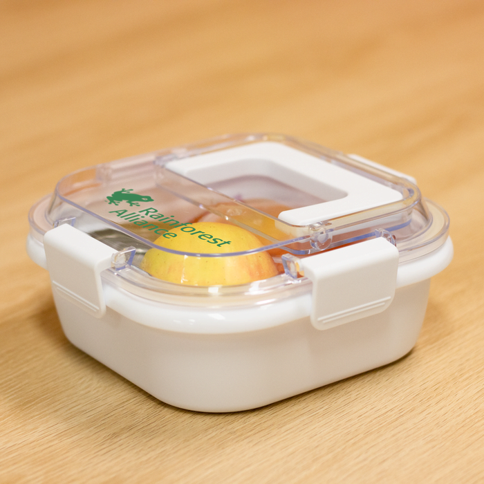 Pac-Man Lunch Box with Handle - A white lunch box with a clear lid, featuring a green logo and a secure clip closure.